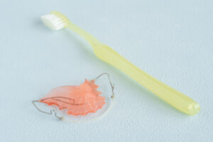 歯科矯正で使用するリテーナーと歯ブラシ