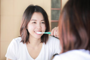 鏡の前で歯磨きをしている女性