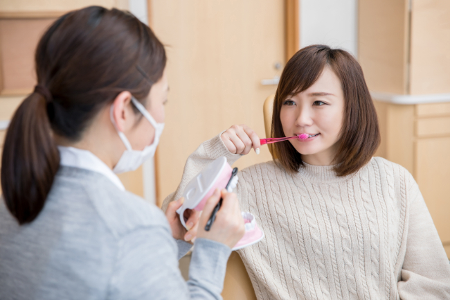 歯磨き指導を受け実践する女性