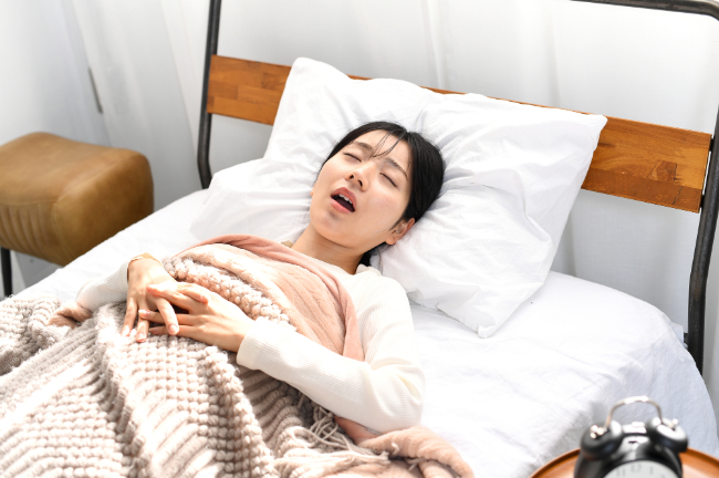 出っ歯になる原因となる口呼吸で眠る女性