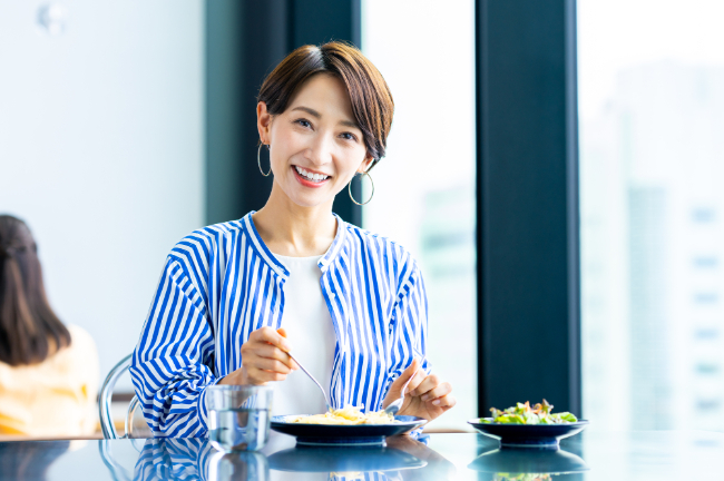 セラミックの歯にし笑顔で食事をする女性