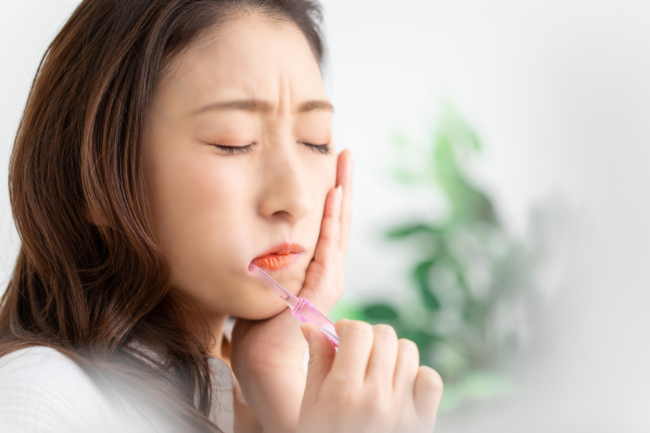 虫歯の初期症状で歯がしみる女性
