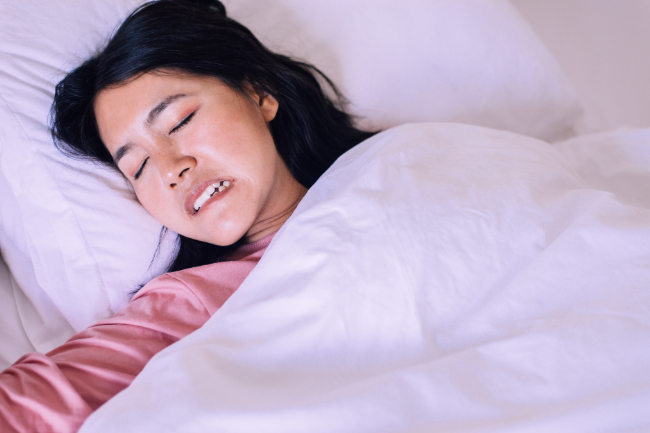 歯ぎしりをしながら眠る女性