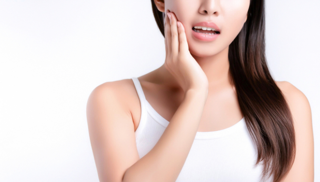 虫歯の治療後にホワイトニングをし痛みを感じる女性