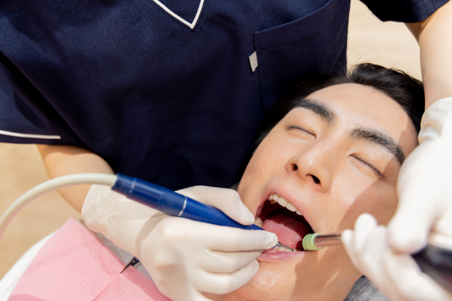 歯科医院でクリーニングを受ける男性