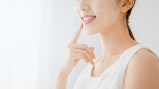 きれいな前歯を指さす女性