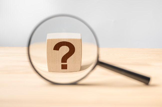 クエスチョンマークが描かれた木製のブロックと虫眼鏡