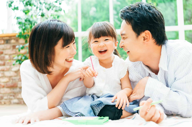 お絵描きをする子どもと笑顔の両親