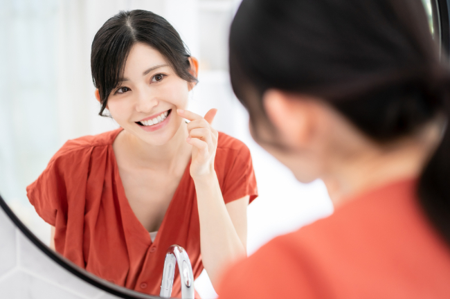 銀歯を白くして嬉しそうに鏡を見る女性