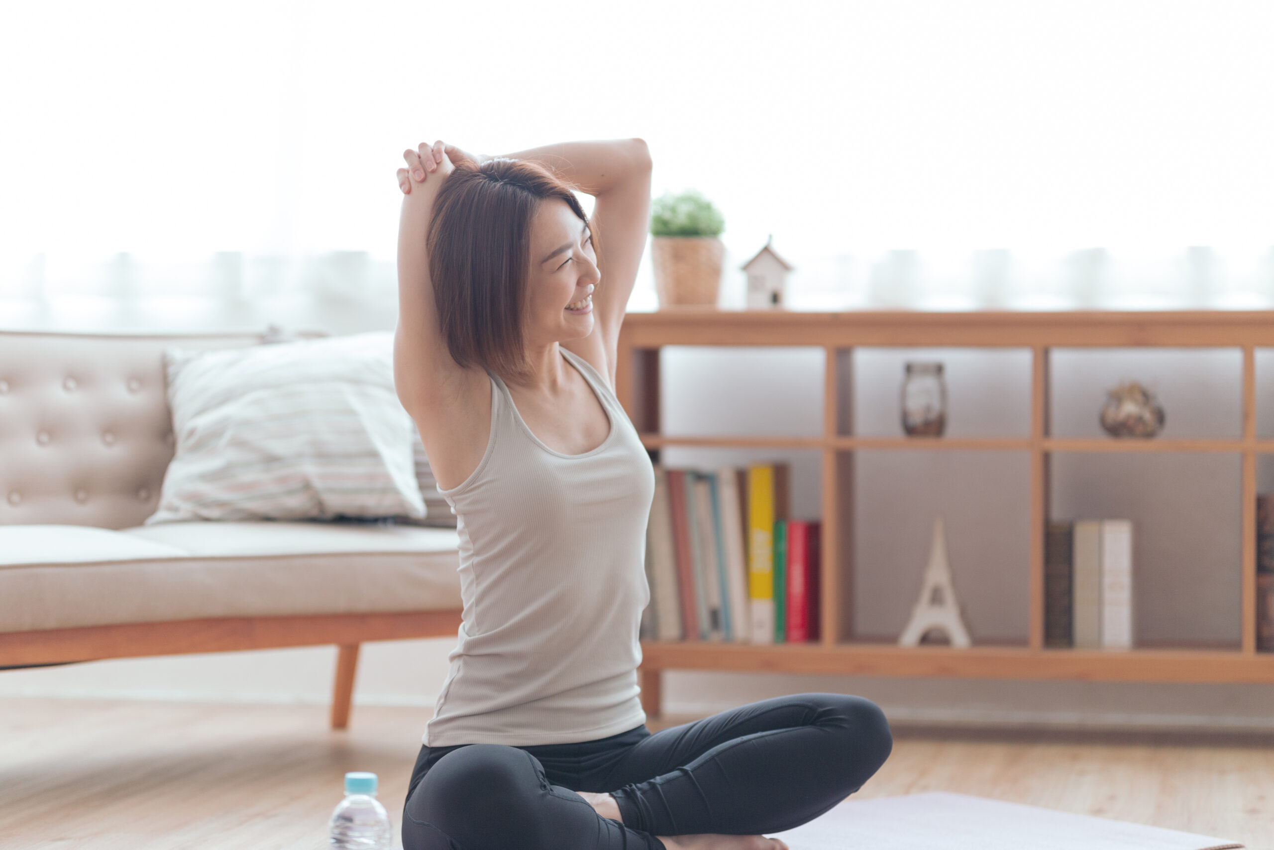 自宅でストレッチを行い健康的な生活を送る女性のイメージ
