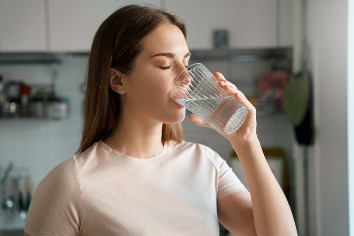 インビザラインのマウスピースをしたまま水を飲む女性